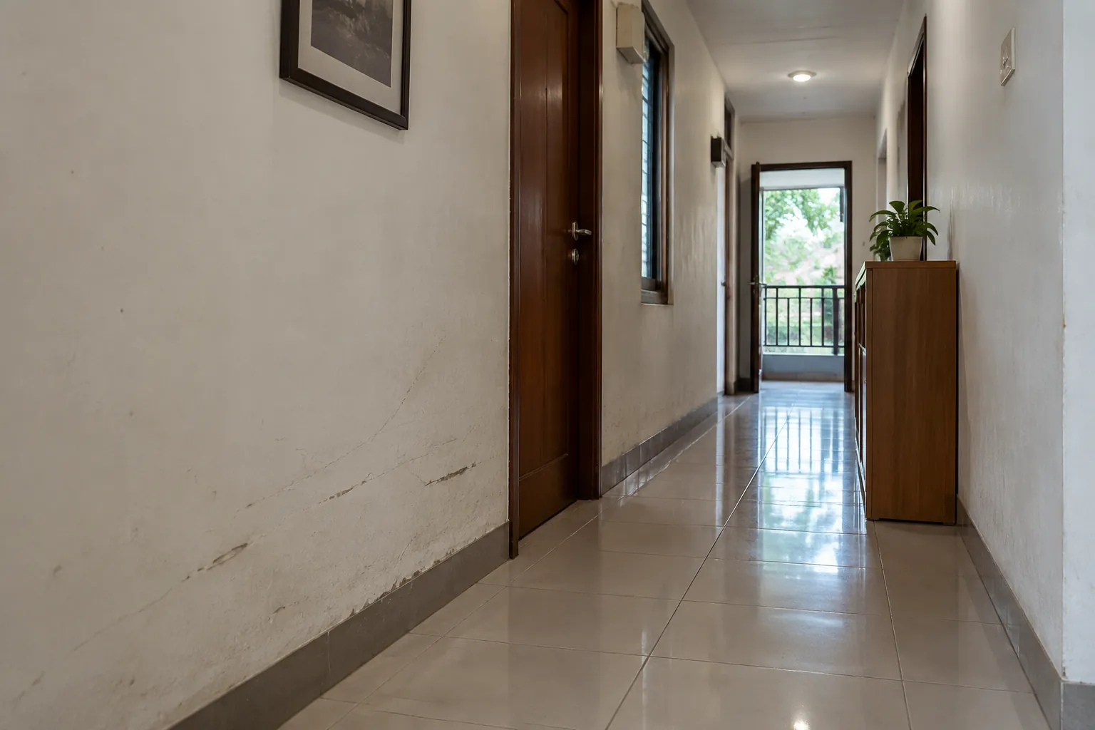 Lorong rumah dengan noda kecil pada dinding