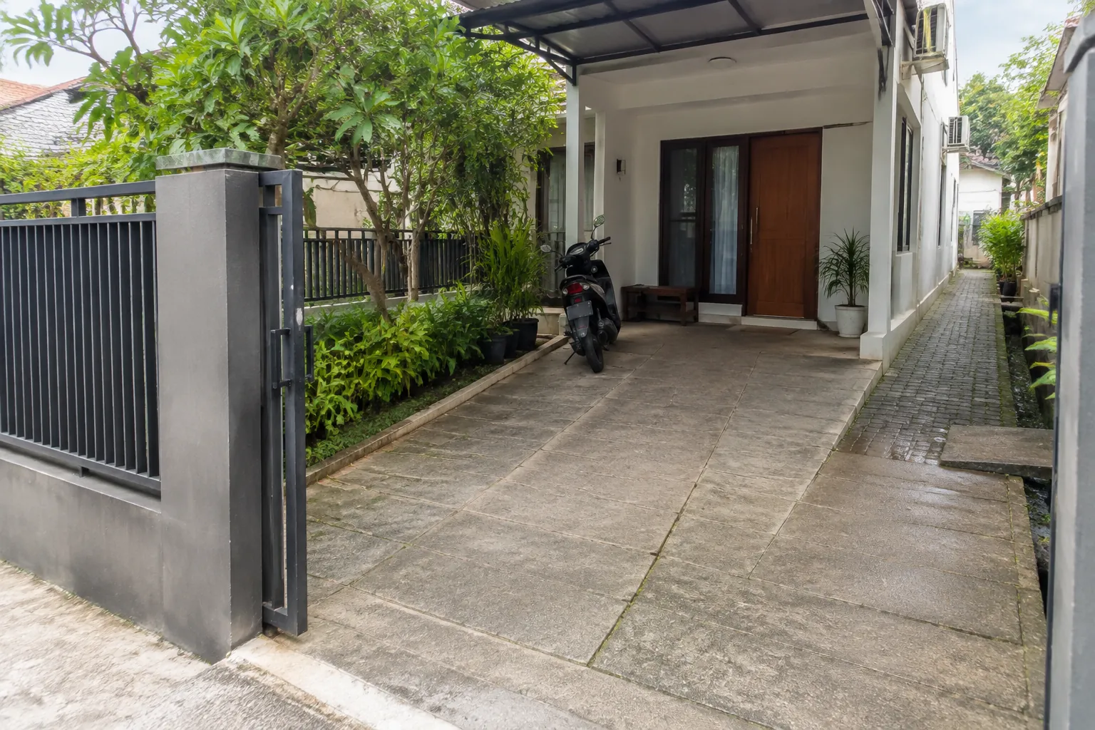 Jalur kendaraan dan pejalan kaki terlihat dari gerbang menuju rumah