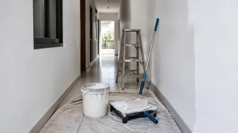 Lorong rumah dilindungi plastik saat pekerjaan pengecatan