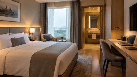 Kamar hotel dengan lampu di sisi tempat tidur dan meja