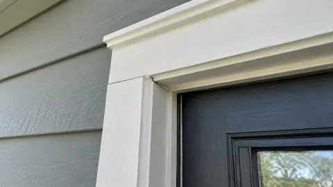 Trim putih pada sudut atas kusen pintu luar