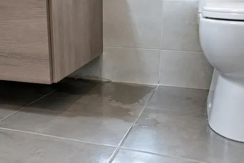 Air pada lantai kamar mandi di bawah kabinet gantung