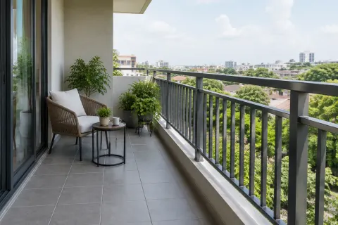 Balkon dengan pagar logam, kursi, dan tanaman pot