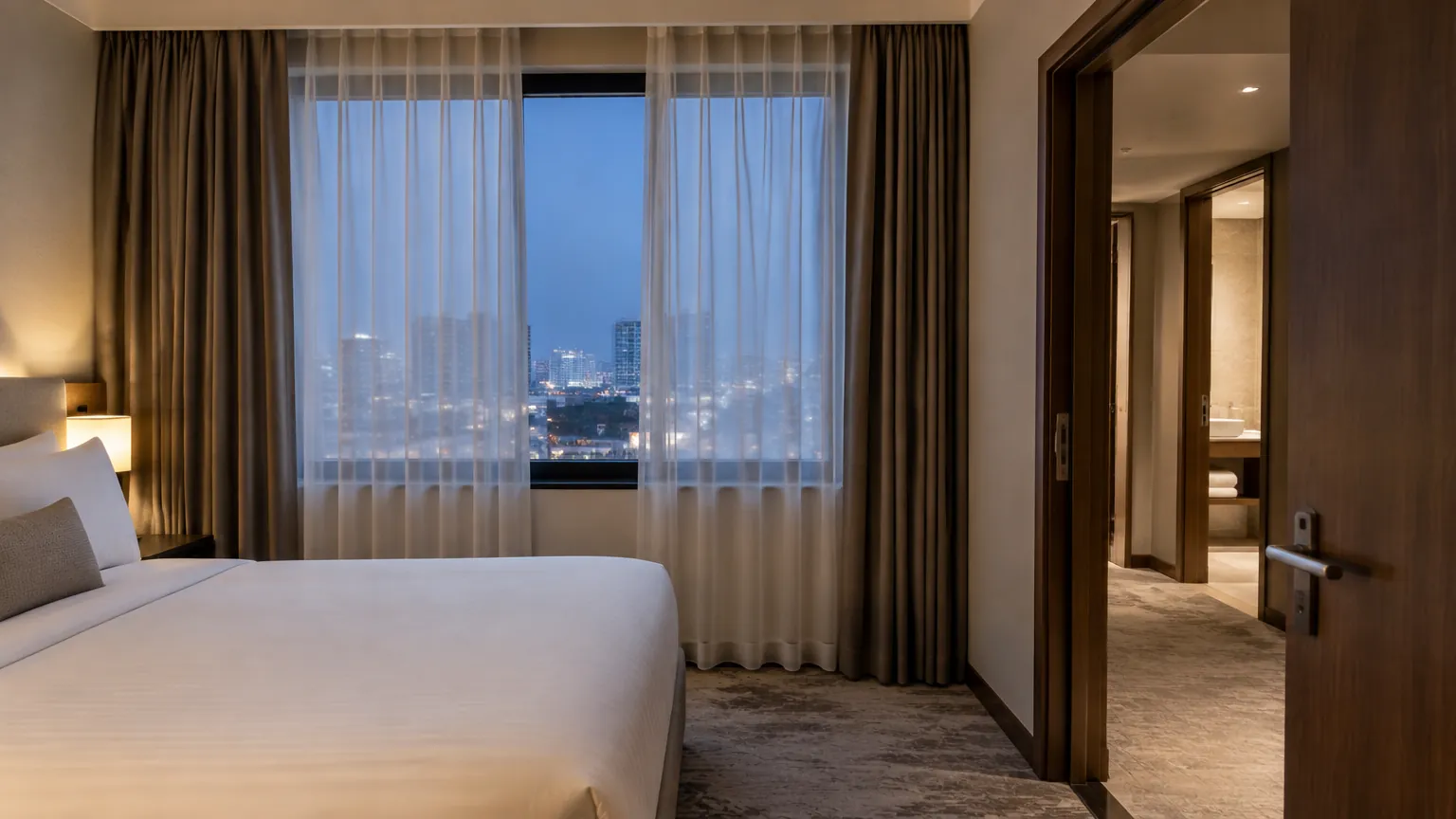 Jendela kamar hotel dengan tirai tipis dan tirai gelap