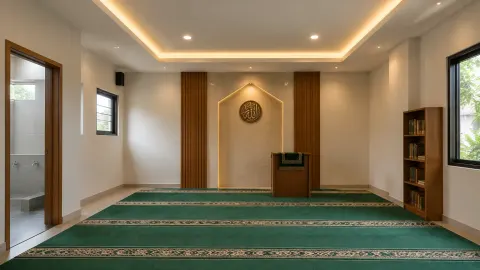 Mushola dengan karpet hijau dan lampu tersembunyi di plafon