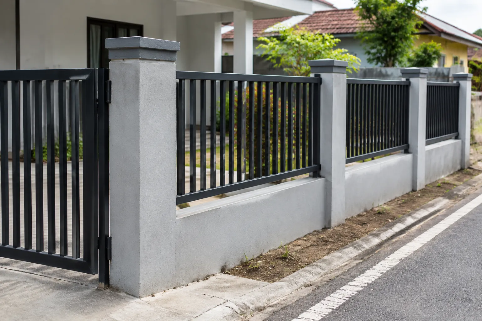 Tiang dan panel pagar logam pada tepi jalan