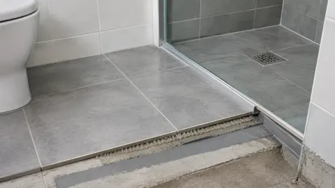 Lantai kamar mandi dengan bagian ambang yang belum selesai dipasang keramik