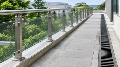 Railing kaca dengan drainase memanjang di sisinya