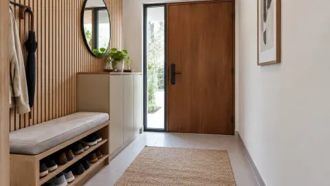 Pintu depan dengan bangku serta cermin di foyer