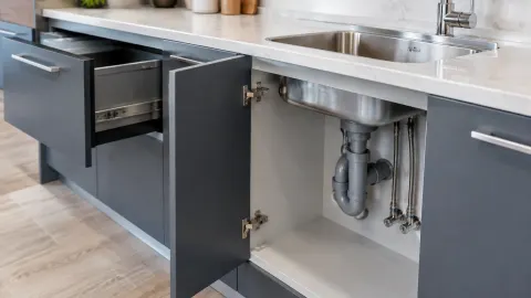 Pipa wastafel terlihat di dalam kabinet kitchen set