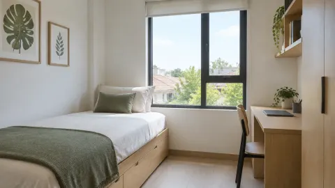 Kamar tidur kecil dengan tempat tidur di bawah jendela