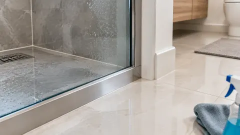Trim putih di pertemuan lantai dan kamar mandi