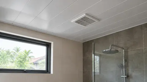 Plafon panel putih dengan kisi udara di kamar mandi