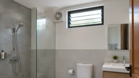 Jendela dan kipas ventilasi pada dinding kamar mandi