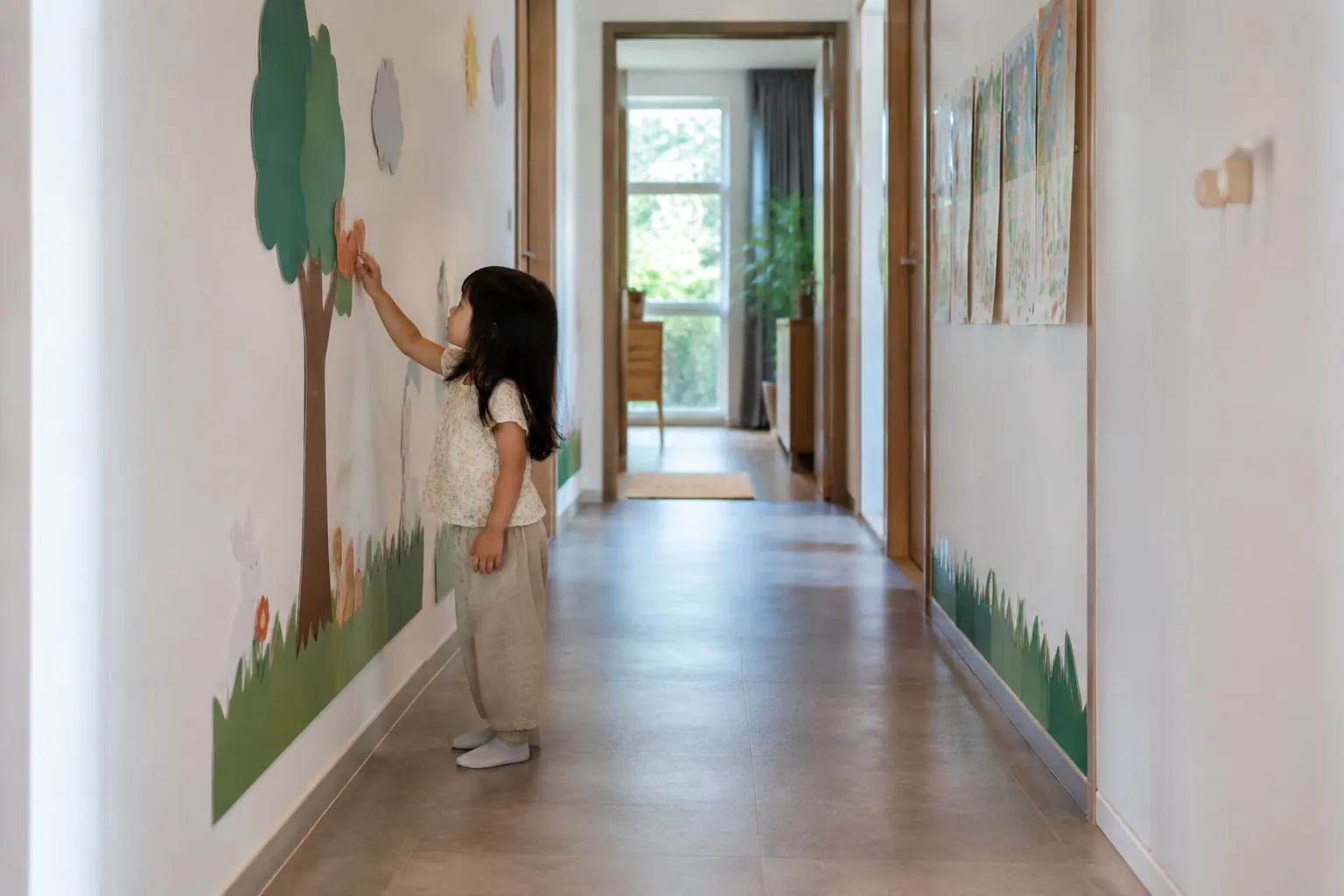 Anak menyentuh dinding lorong yang memiliki gambar dan bekas penggunaan
