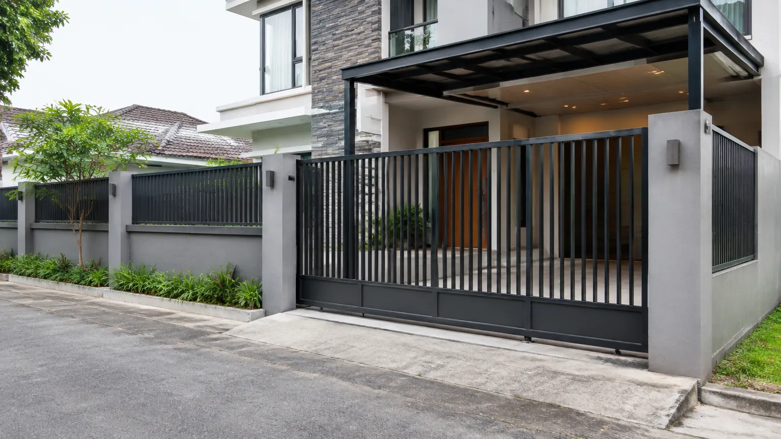 Gerbang dan pagar logam berwarna gelap di depan rumah