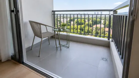 Balkon kecil dengan kursi dan saluran lantai