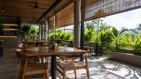 Meja makan kafe semi terbuka dengan tirai peneduh