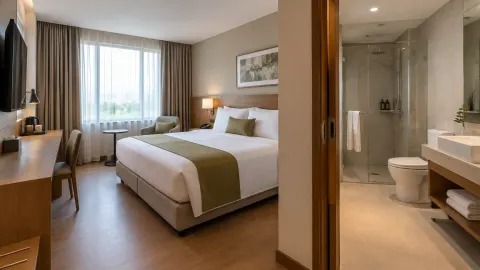 Kamar hotel dengan tempat tidur, meja, dan kamar mandi