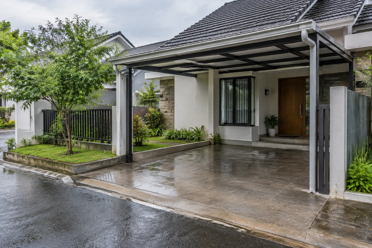 Talang atap dan pipa turun mengarahkan air ke area carport