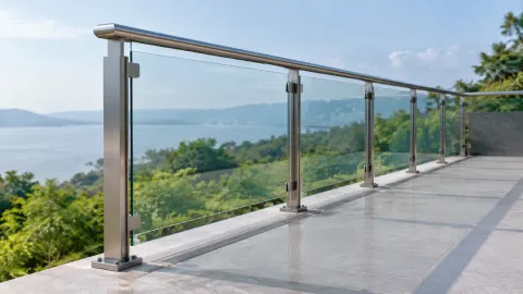 Railing kaca dan tiang logam di tepi teras