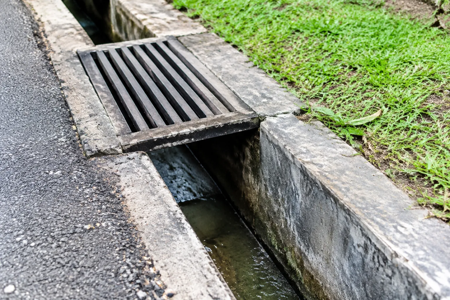 Kisi saluran drainase terbuka di tepi jalan