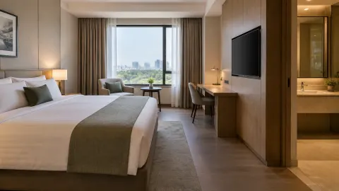 Kamar hotel dengan tempat tidur, meja kerja, dan kamar mandi