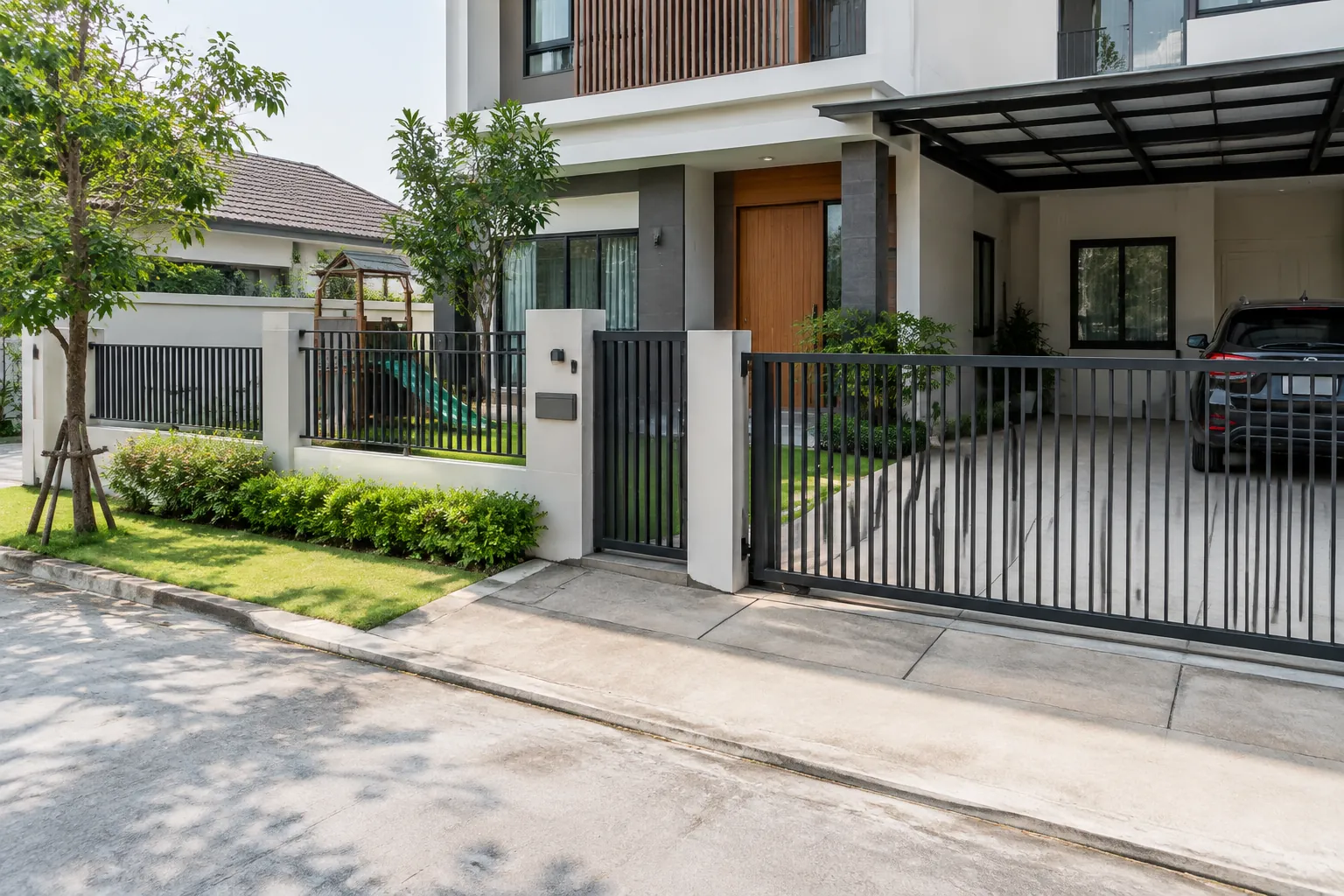 Gerbang dan pagar membentuk jalur masuk dari jalan ke rumah