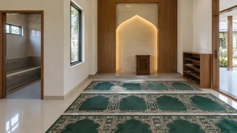 Mushola dengan karpet hijau dan ceruk arah salat