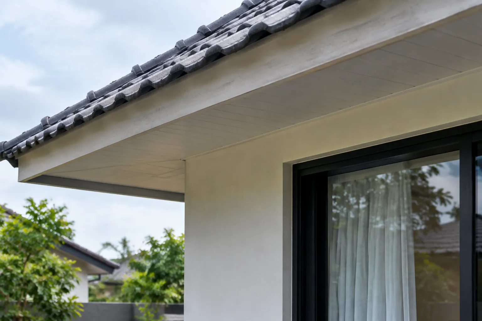 Tepi atap genteng rumah di atas jendela