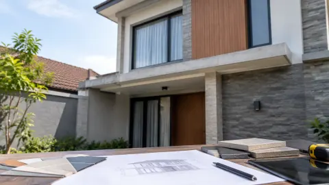 Fasad rumah dengan contoh bahan di atas meja rencana