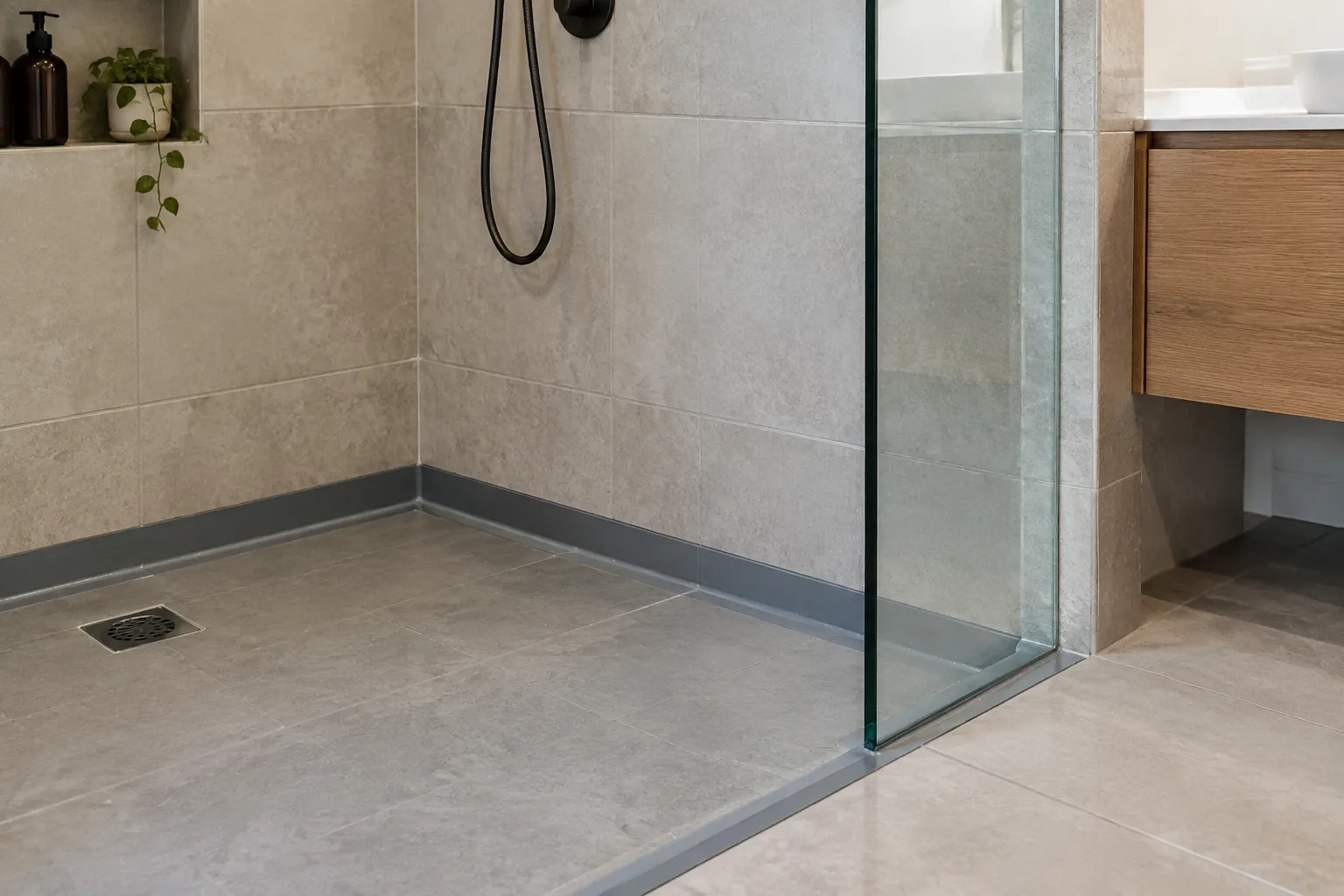 Lantai shower dan pertemuan dinding terlihat di area basah