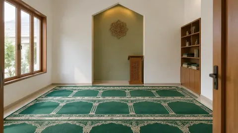 Mushola dengan karpet hijau dan area dinding kosong