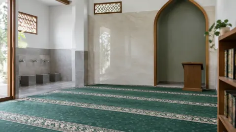 Ruang mushola dengan dinding terang dan karpet hijau