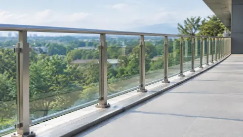 Railing kaca menghadap pemandangan pepohonan