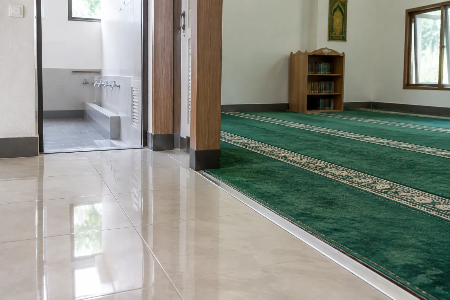Tepi karpet bertemu lantai keramik pada pintu masuk ruang salat