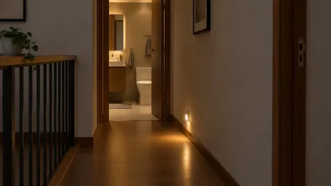 Lorong rumah bercahaya redup menuju pintu kamar mandi