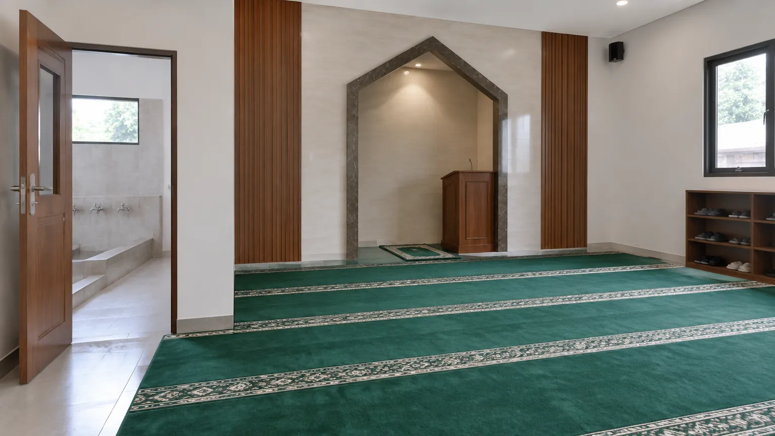Mushola dengan karpet hijau dan ceruk dinding