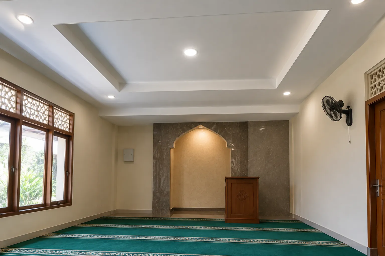 Musala dengan plafon bertingkat dan cahaya di sekitar ceruk mihrab