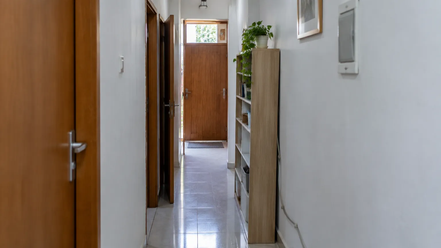 Lorong sempit dengan pintu dan lemari di sisi dinding