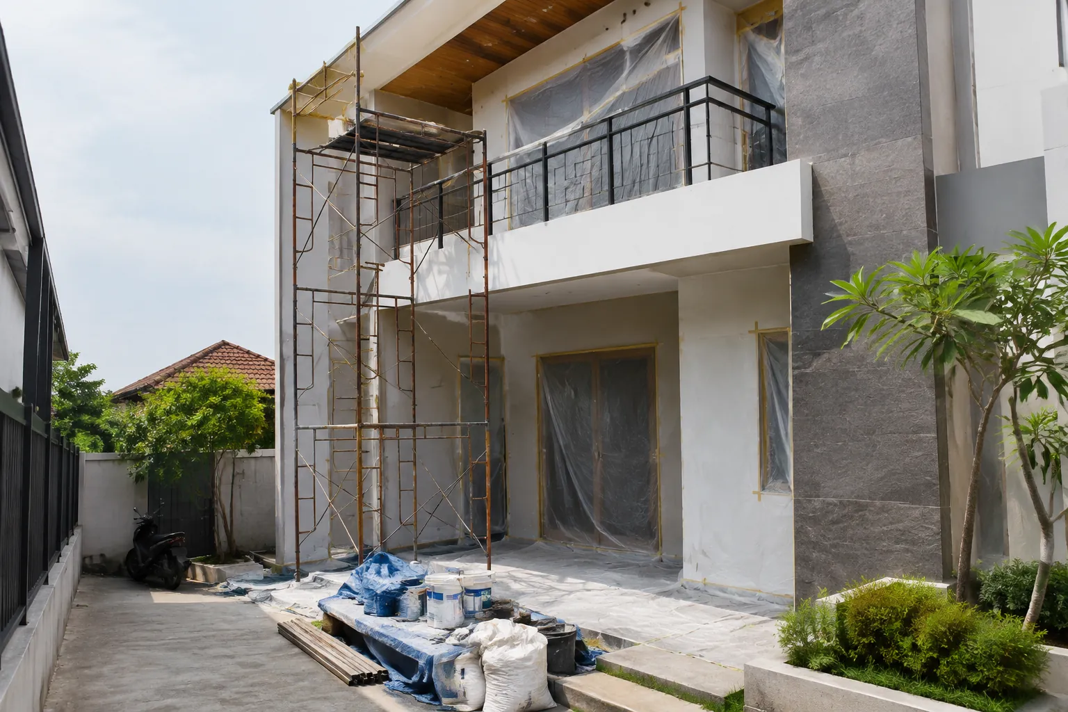 Perancah berdiri di depan dinding luar rumah yang sedang diperbaiki