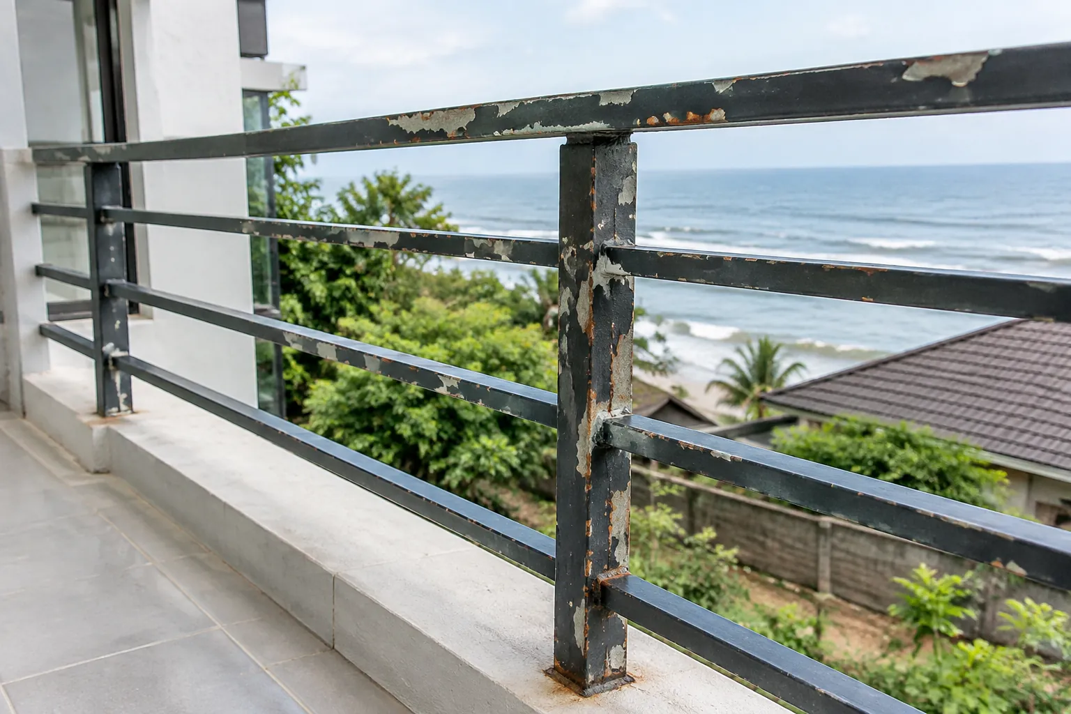 Lapisan cat terkelupas pada pagar logam dekat pantai
