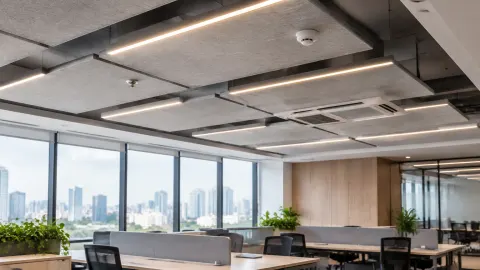 Ruang kerja bersama dengan panel plafon abu-abu dan lampu linear