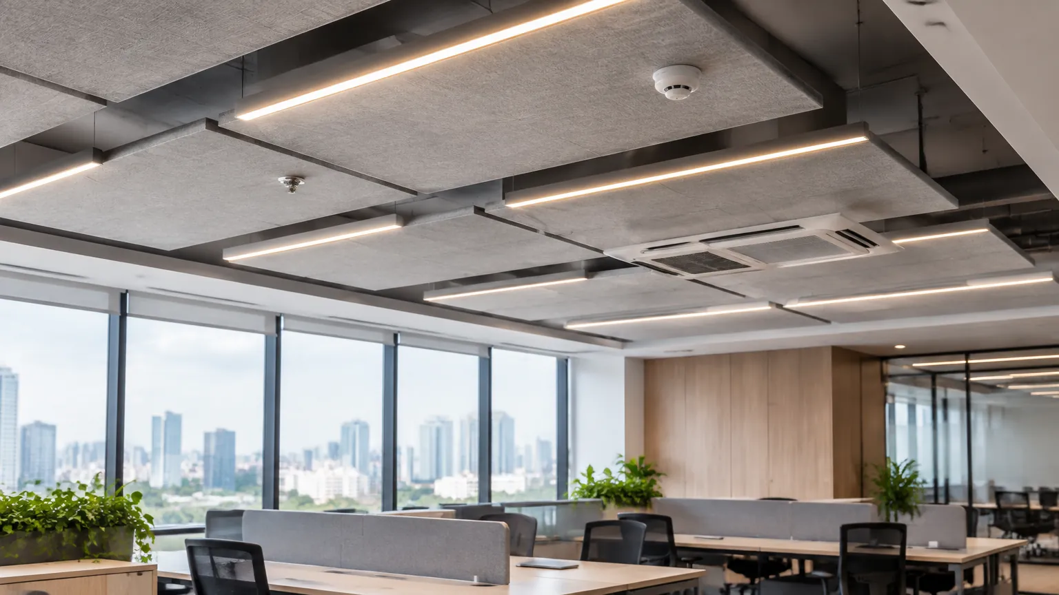 Ruang kerja bersama dengan panel plafon abu-abu dan lampu linear