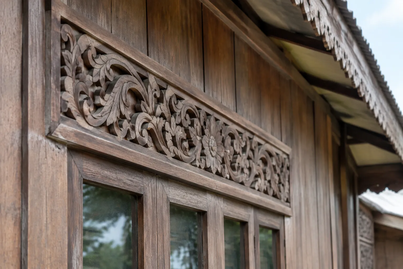 Ukiran kayu tradisional di atas jendela rumah