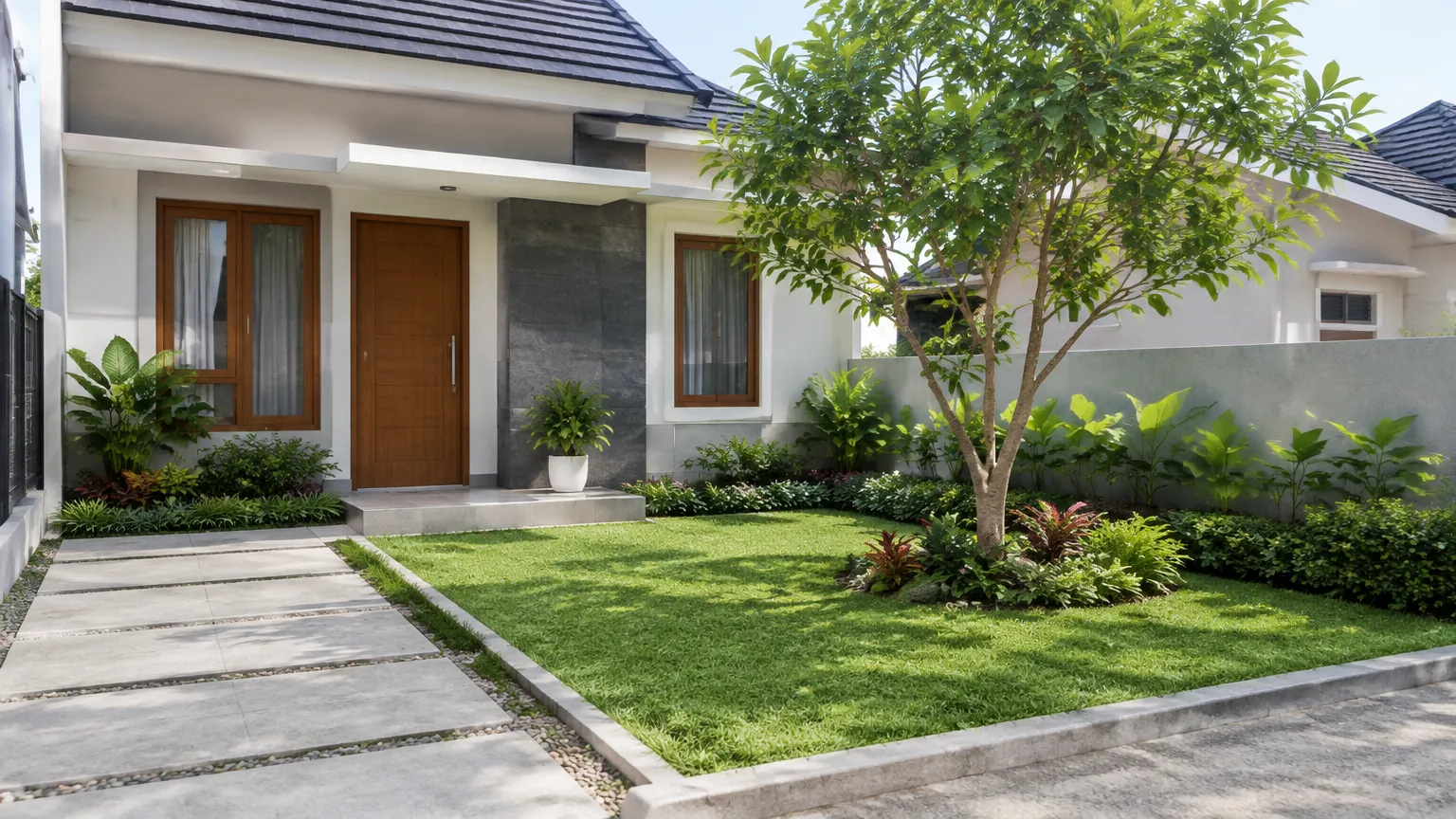 Halaman depan rumah dengan pohon, rumput, dan jalur pijakan