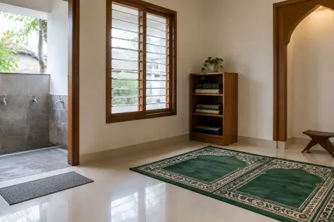 Ruang musala dengan jendela dan sajadah hijau