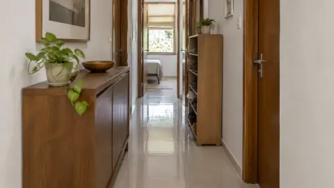Lorong rumah sempit dengan lemari dan pintu pada kedua sisinya