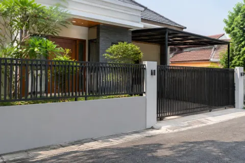 Pagar logam hitam pada sisi depan rumah.
