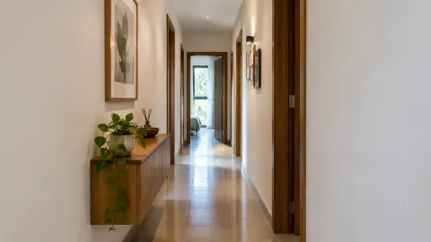 Lorong rumah dengan dinding terang dan beberapa gambar